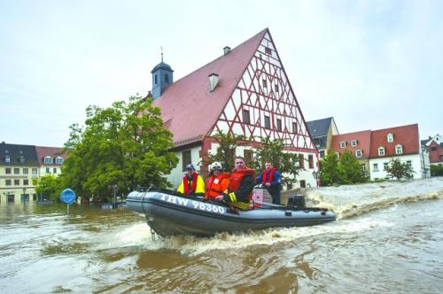 6 月3 日,在遭遇嚴(yán)重洪災(zāi)的德國東部城市格里馬,救援人員使用救生筏幫助居民轉(zhuǎn)移。